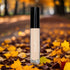 Comma concealer tube against autumn leaves